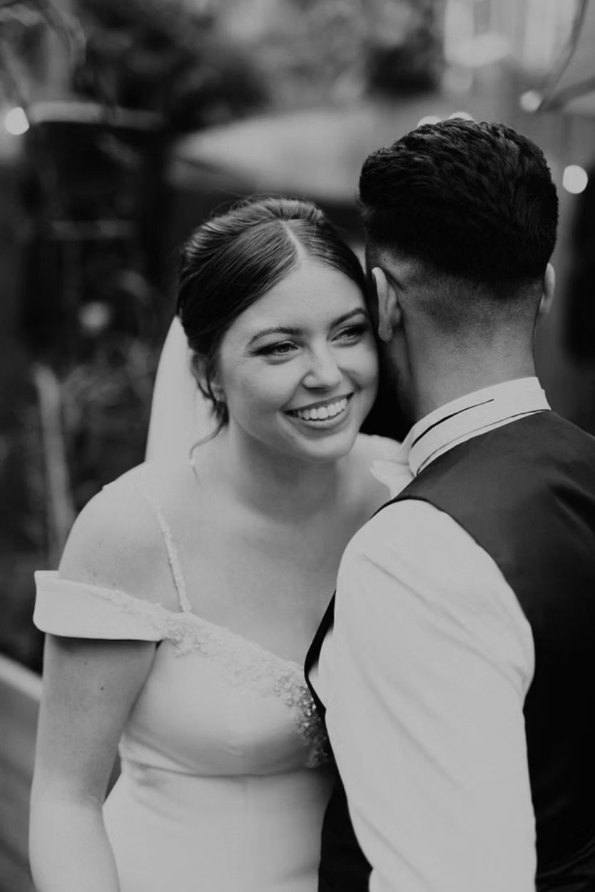 Bride and groom close together, in black and white