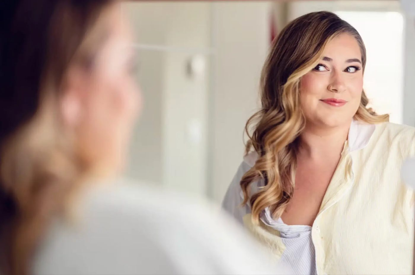 Hair styled in loose waves, seen in a mirror