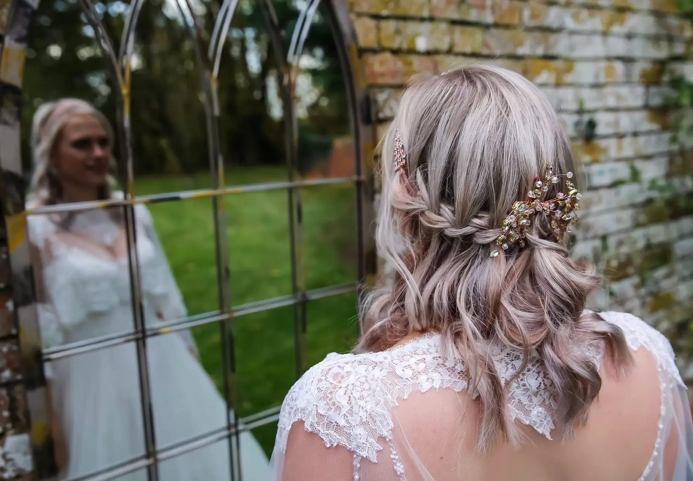 Bride seen in an arched window mirror